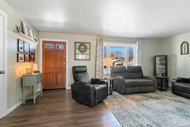 living area featuring baseboards and dark wood finished floors