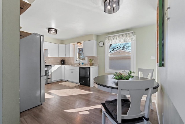 kitchen with tasteful backsplash, wood finished floors, freestanding refrigerator, stove, and dishwasher