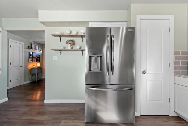 kitchen featuring tasteful backsplash, stainless steel fridge, white cabinets, and dark wood-style flooring