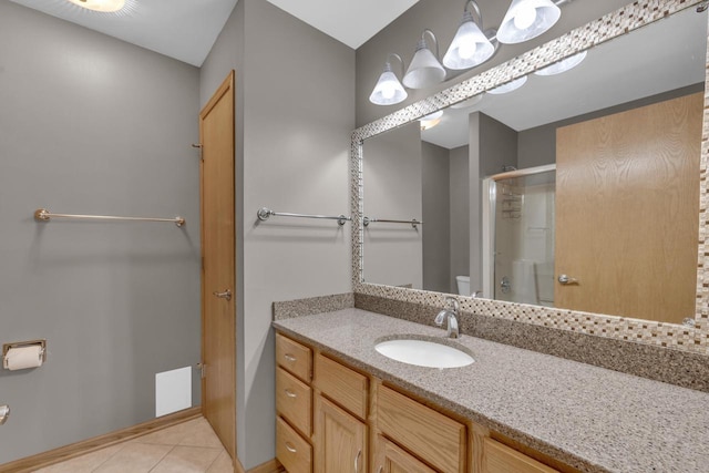 full bathroom featuring vanity, a shower stall, toilet, and tile patterned floors