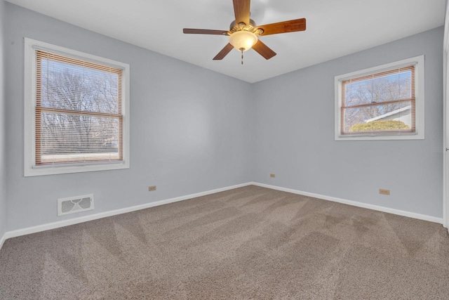 empty room featuring visible vents, baseboards, a ceiling fan, and carpet flooring