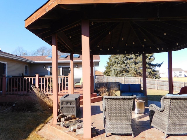 view of patio featuring an outdoor living space, a gazebo, and fence