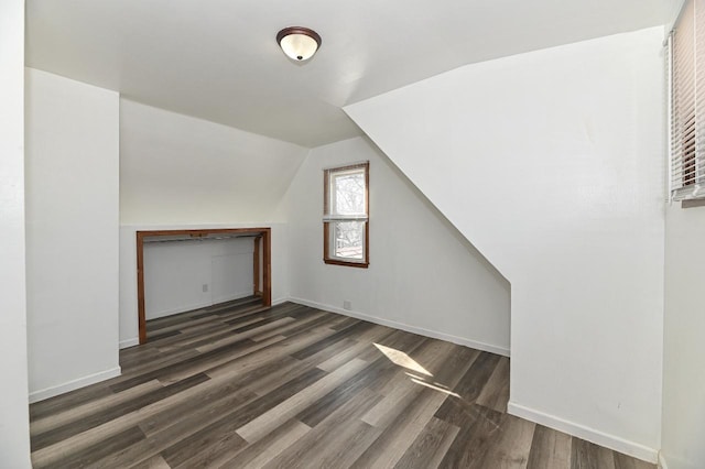 bonus room featuring wood finished floors, baseboards, and vaulted ceiling