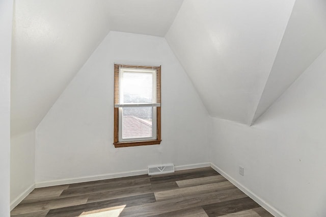 bonus room featuring vaulted ceiling, visible vents, baseboards, and dark wood-style flooring