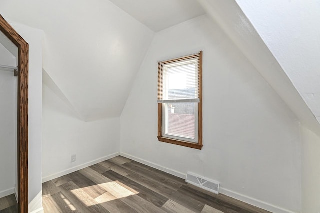 bonus room featuring visible vents, baseboards, and dark wood-style flooring