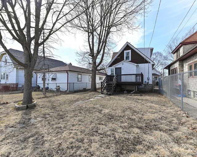 rear view of house featuring a wooden deck, a fenced backyard, and a chimney