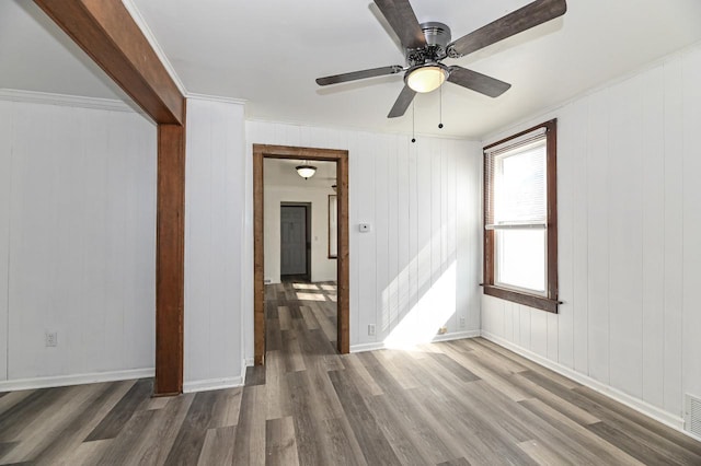 unfurnished room with visible vents, baseboards, wood finished floors, and a ceiling fan