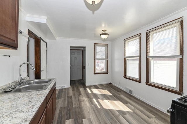 kitchen with visible vents, ornamental molding, light countertops, and a sink