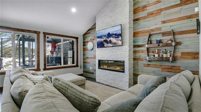 living area with recessed lighting, lofted ceiling, wood walls, and a fireplace