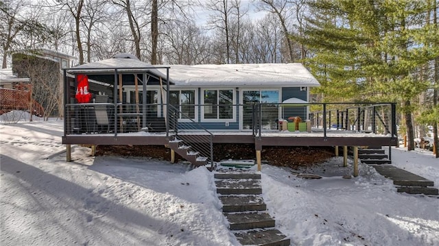 snow covered property featuring stairs and a deck