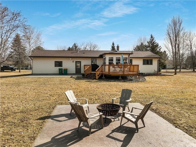 rear view of property with central AC unit, an outdoor fire pit, a yard, a deck, and a patio area