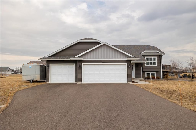 view of front of home featuring aphalt driveway, a garage, and a front lawn