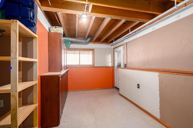 basement featuring tile patterned floors and baseboards