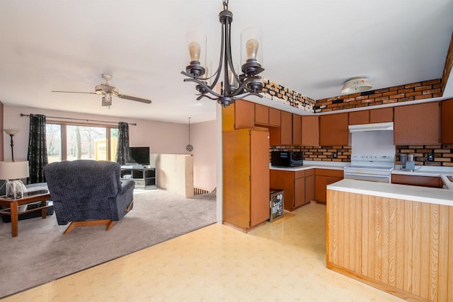 kitchen with under cabinet range hood, light floors, pendant lighting, light countertops, and range with electric stovetop