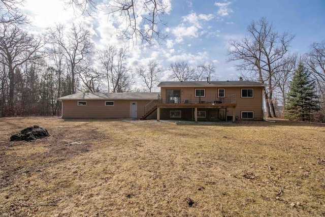 rear view of house featuring stairway, a yard, and a deck