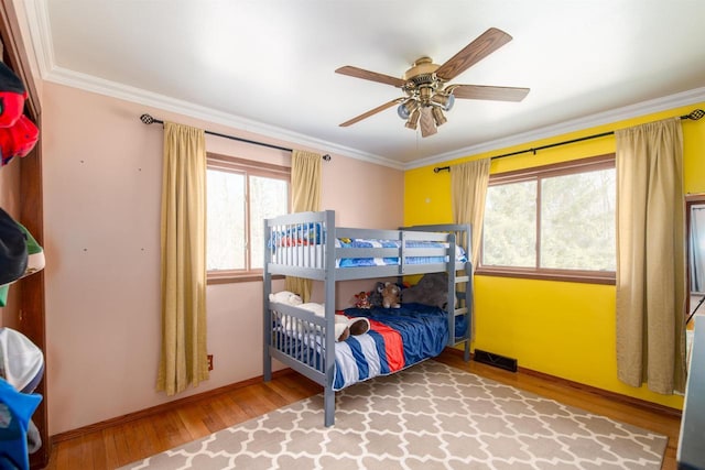 bedroom featuring visible vents, ornamental molding, baseboards, and wood finished floors