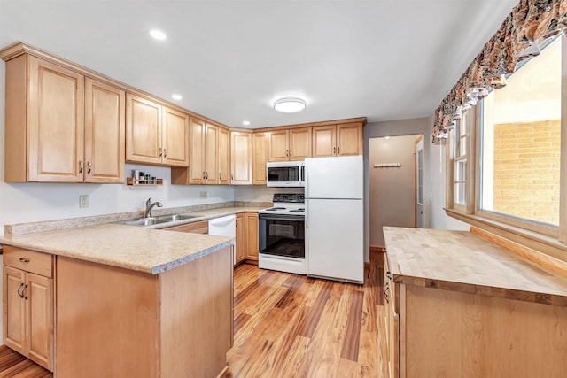 kitchen with white appliances, light brown cabinets, light wood finished floors, butcher block countertops, and a sink