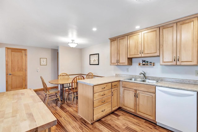 kitchen featuring a sink, light brown cabinets, light wood-style flooring, and white dishwasher