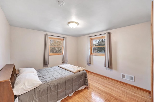 bedroom featuring hardwood / wood-style flooring, baseboards, and visible vents