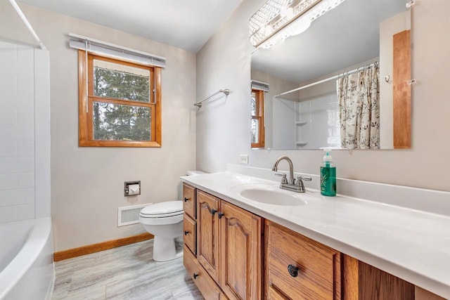 bathroom featuring vanity, wood finished floors, visible vents, baseboards, and toilet