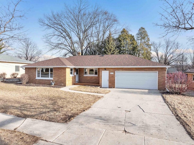 ranch-style house with brick siding, concrete driveway, roof with shingles, a chimney, and an attached garage