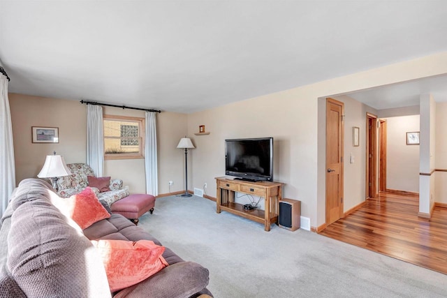 living room with baseboards and light carpet