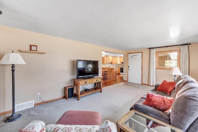 living room featuring carpet flooring, baseboards, and visible vents