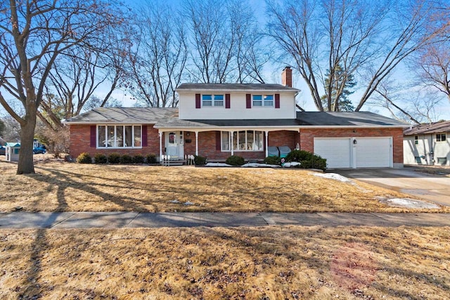 traditional-style home featuring a garage, brick siding, a chimney, and driveway