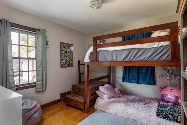 bedroom with visible vents, baseboards, and wood finished floors