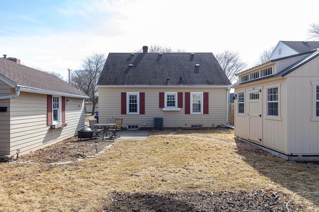 back of house with an outbuilding, crawl space, a shingled roof, and a patio