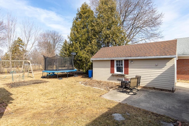 view of yard featuring a patio, a trampoline, and an outdoor structure