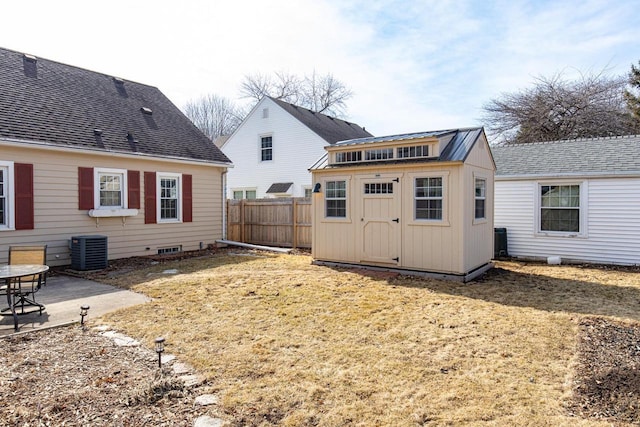 rear view of house with fence, central air condition unit, a shed, an outdoor structure, and a patio