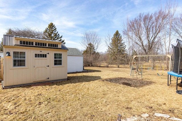 view of yard featuring a storage unit, an outdoor structure, and a trampoline