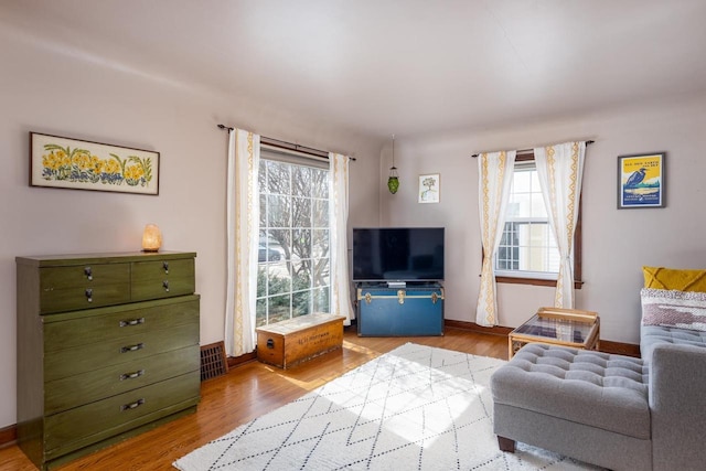 living room featuring visible vents, wood finished floors, and baseboards