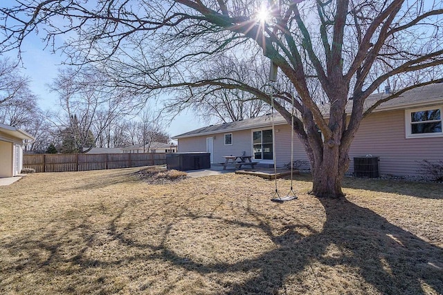 view of yard featuring a patio area, fence, central AC, and a hot tub