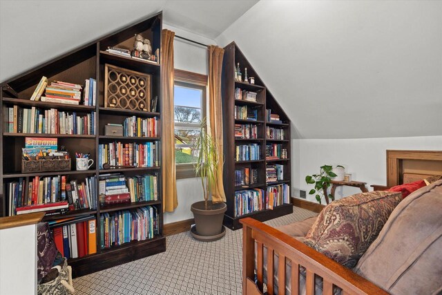 living area with baseboards and vaulted ceiling