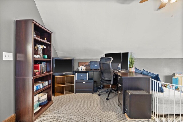 carpeted office with a ceiling fan and vaulted ceiling