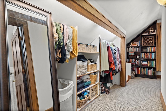 walk in closet featuring carpet flooring and vaulted ceiling