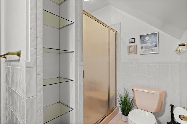 full bathroom featuring a shower stall, tile walls, toilet, and vaulted ceiling