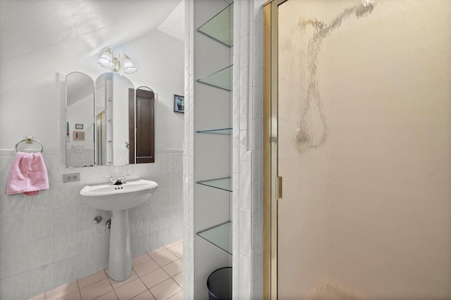 bathroom featuring tile patterned floors, tile walls, and a shower stall