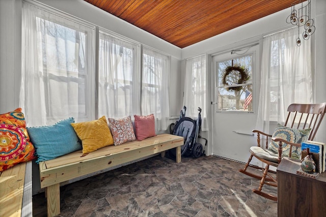 sitting room featuring stone finish flooring, plenty of natural light, and wooden ceiling