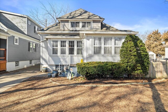 rear view of property featuring fence