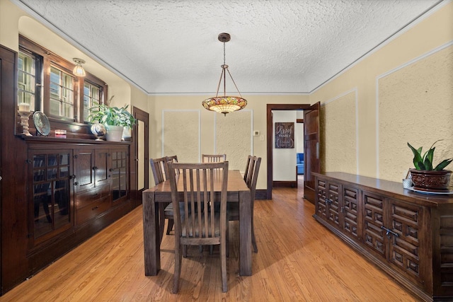 dining space featuring a textured ceiling and wood finished floors