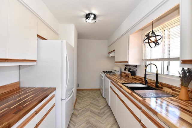 kitchen featuring a sink, white appliances, and butcher block countertops