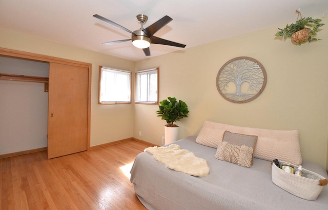 bedroom featuring a closet, a ceiling fan, baseboards, and wood finished floors