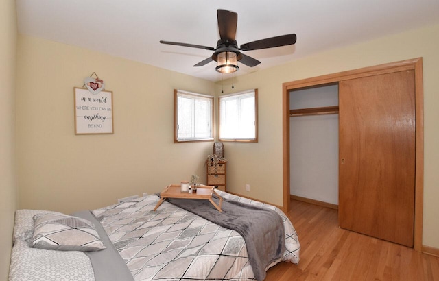 bedroom featuring light wood finished floors, baseboards, a closet, and a ceiling fan