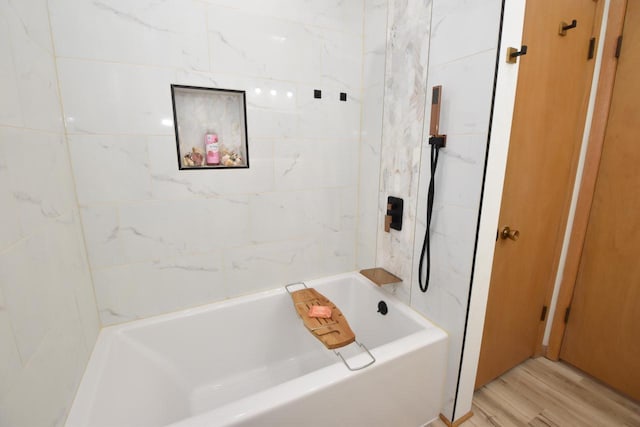 full bath with wood finished floors and a tub to relax in