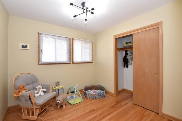 interior space featuring light wood-style flooring, baseboards, and a chandelier