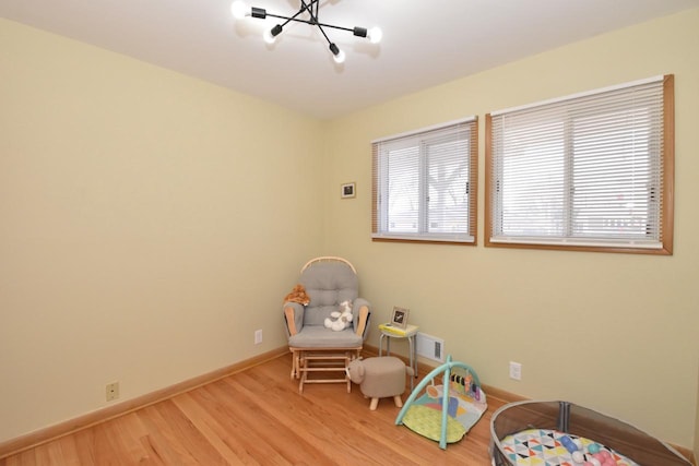 rec room with plenty of natural light, wood finished floors, visible vents, and baseboards