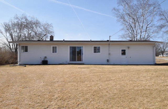 back of property with a lawn and a chimney